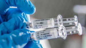 (200414) -- BEIJING, April 14, 2020 (Xinhua) -- A staff member displays samples of the COVID-19 inactivated vaccine at Sinovac Biotech Ltd., in Beijing, capital of China, March 16, 2020. China has approved two COVID-19 inactivated vaccine candidates for c