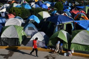 Image: Migrants, most of them asylum seekers sent back to Mexico from the U.S. under the "Remain in Mexico" program officially named Migrant Protection Protocols (MPP), occupy a makeshift encampment in Matamoros